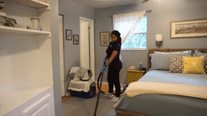 Cleaner Cleaning the Bedroom with Vacuum
