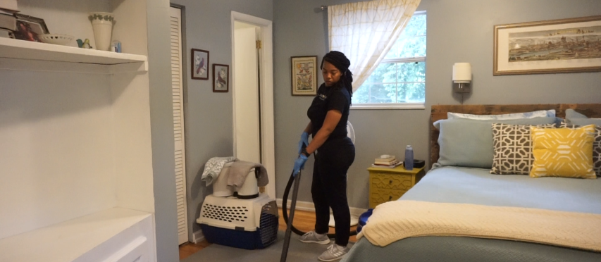 Cleaner Cleaning the Bedroom with Vacuum